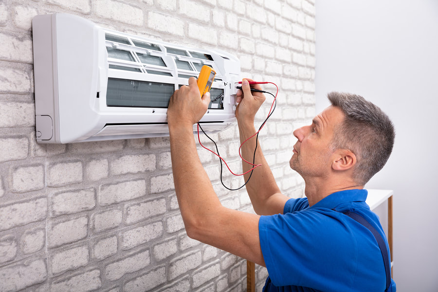 man checking the electrical of the air conditioner